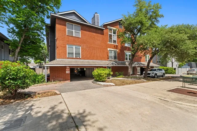 a front view of a house with yard and trees