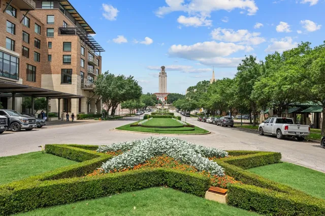 a view of a big yard with cars parked in front of a house