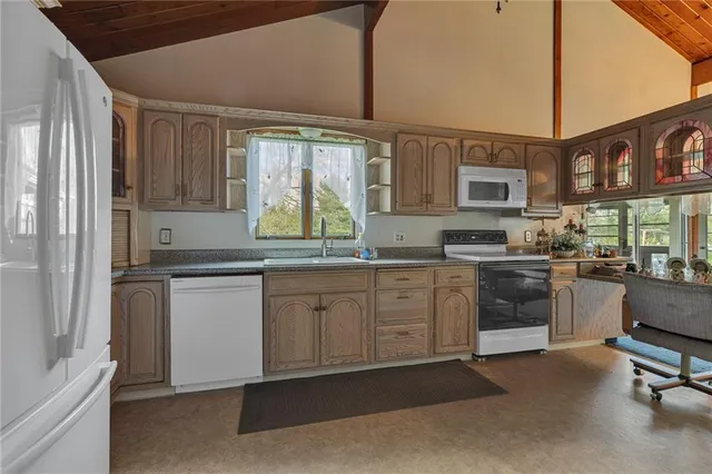 a kitchen with stainless steel appliances granite countertop a stove a sink and a refrigerator