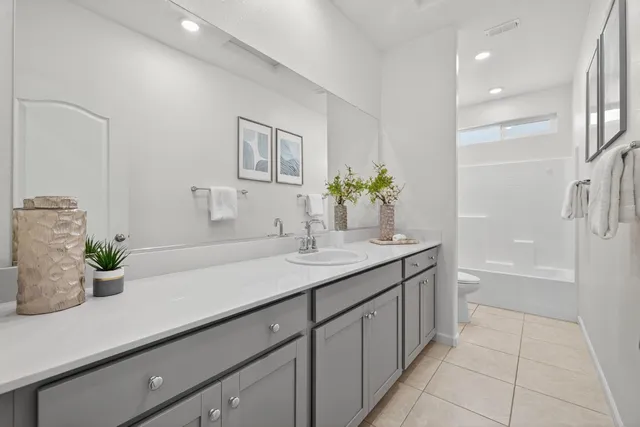 a bathroom with a granite countertop sink a mirror and a bathtub