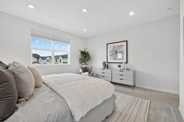 a bedroom with a bed and large windows