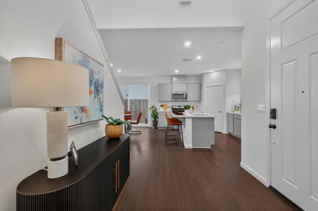 a kitchen view with furniture a refrigerator and wooden floor