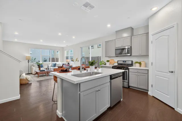 a kitchen with white cabinets and sink