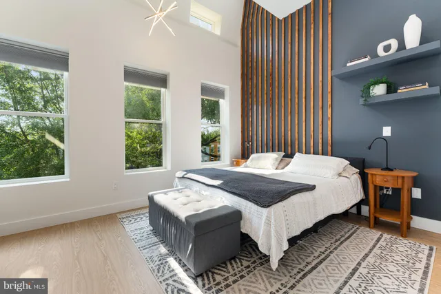 a bed sitting in a bedroom next to a window