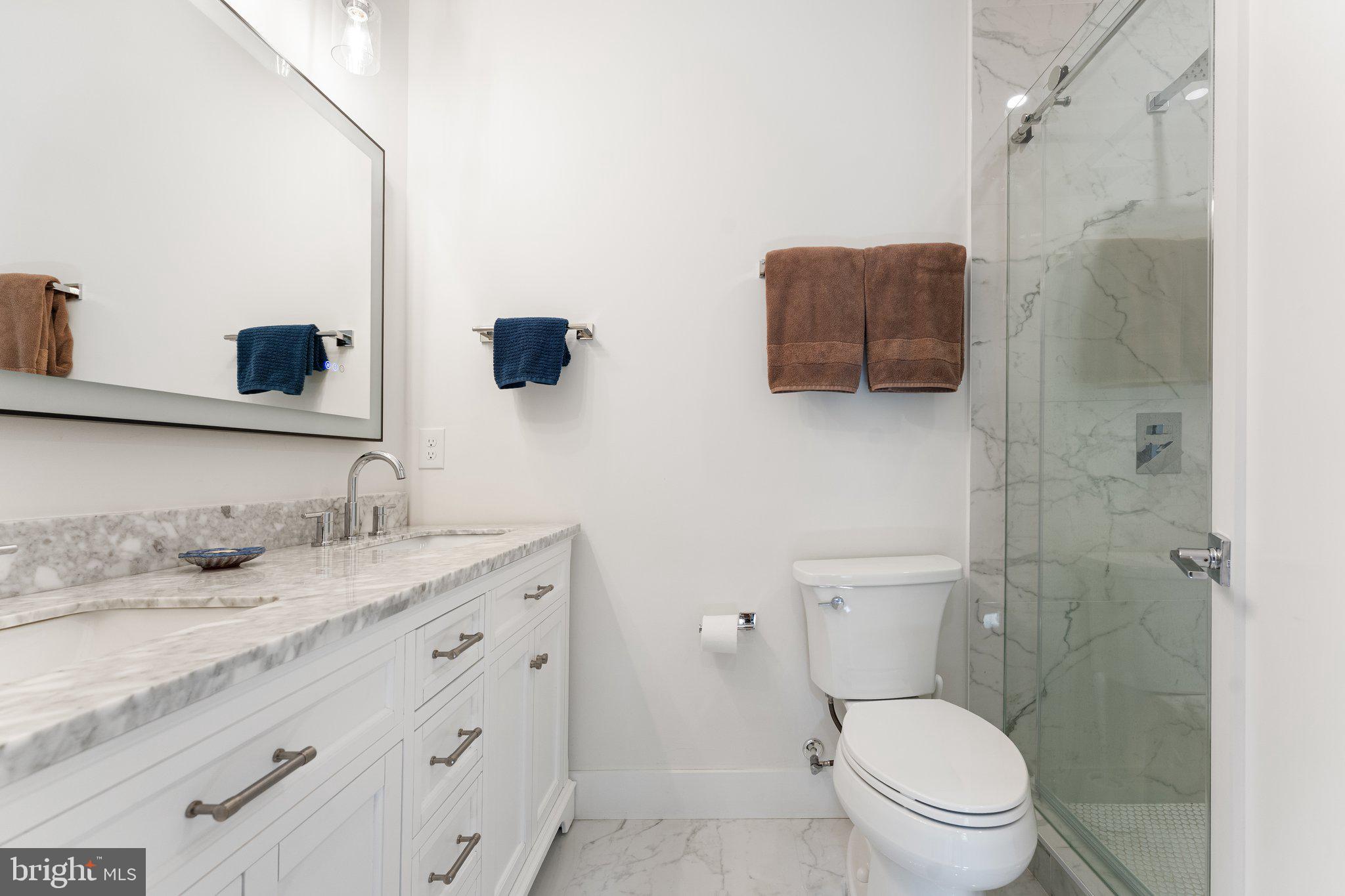 922 8th Street Northeast Washington, DC 20002 - Photo 21 of 44 a bathroom with a granite countertop sink a large mirror and toilet