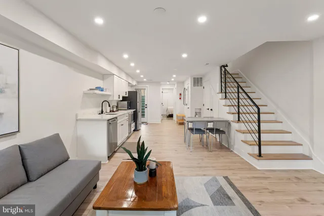a living room with furniture and a dining table with wooden floor