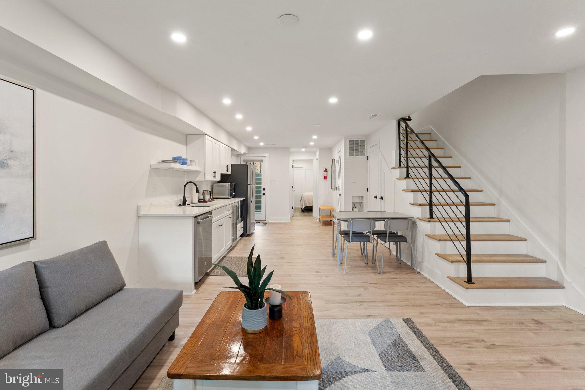 922 8th Street Northeast Washington, DC 20002 - Photo 30 of 44 a living room with furniture and a dining table with wooden floor