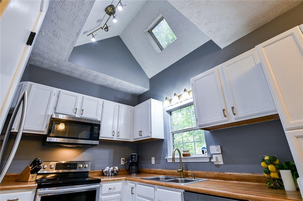 40 Mildred Lane Covington, GA 30016 - Photo 18 of 56 a kitchen with stainless steel appliances granite countertop a sink a stove microwave and cabinets