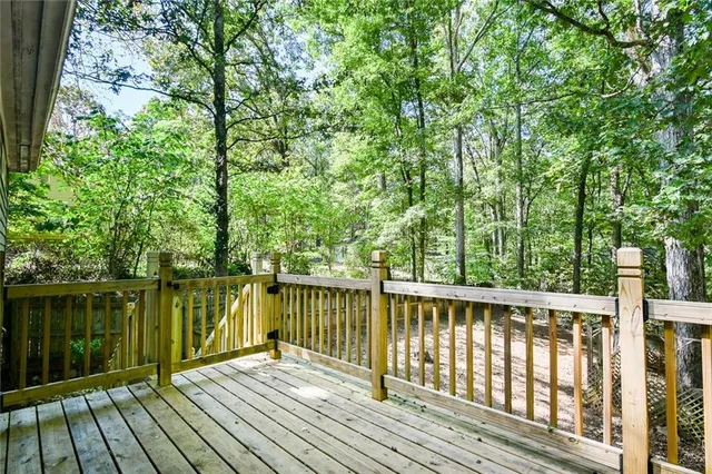 a large kitchen with stainless steel appliances a stove a refrigerator a sink a dining table and chairs with wooden floor