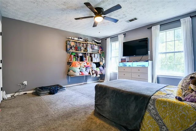 a bedroom with a large bed and wooden floor