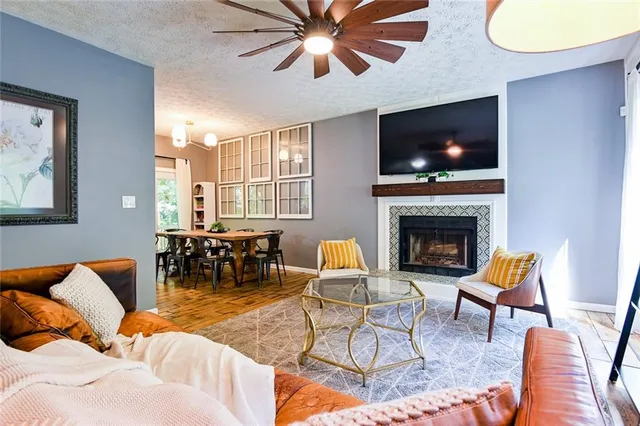 a living room with furniture a flat screen tv and a fireplace