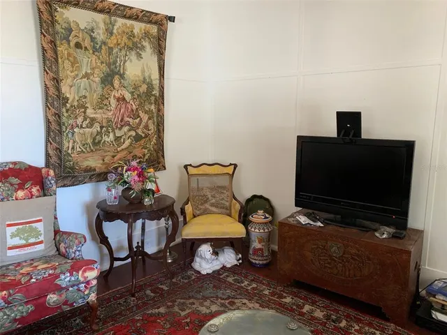 a living room with furniture a flat screen tv and a window