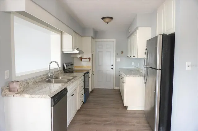 a kitchen with a refrigerator sink and stove