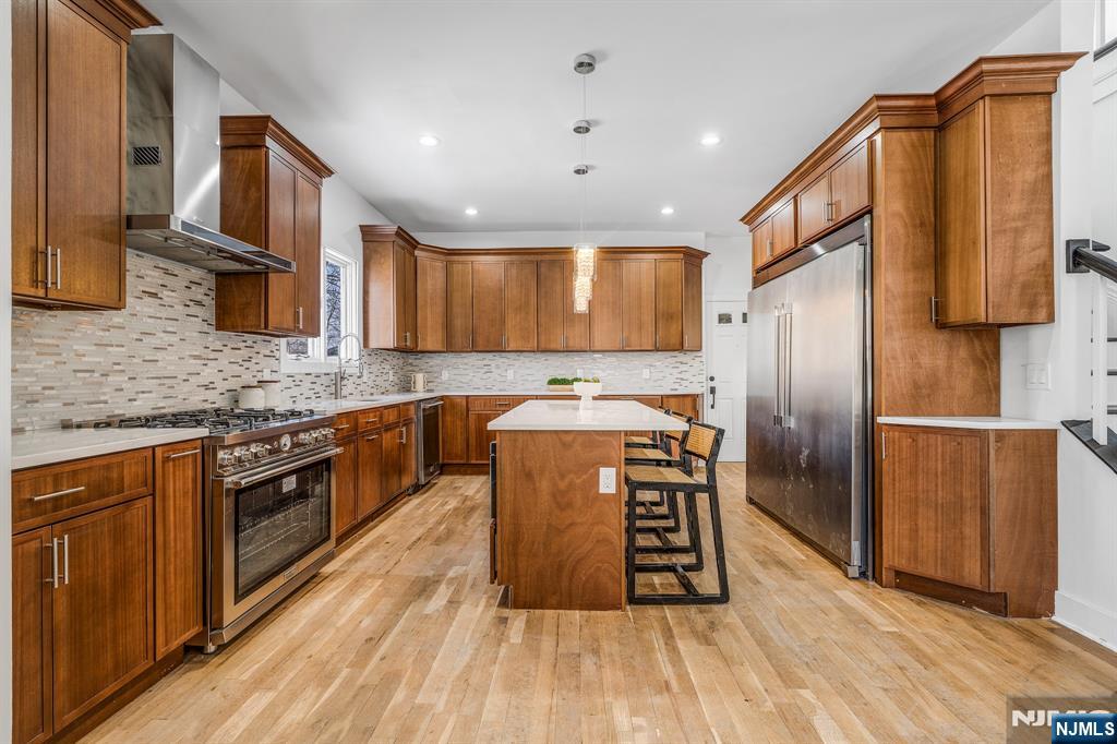 60 Stanley Road South Orange, NJ 07079 - Photo 9 of 40 a kitchen with stainless steel appliances granite countertop a refrigerator a sink dishwasher a stove with wooden cabinets and floor