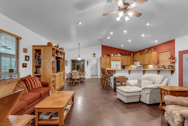 a living room with furniture kitchen view and a large window