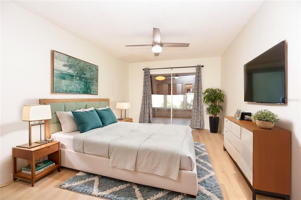 2025 Sylvester Road, Unit S2 Lakeland, FL 33803 - Photo 15 of 36 a bedroom with a bed a mirror on dresser and a flat screen tv