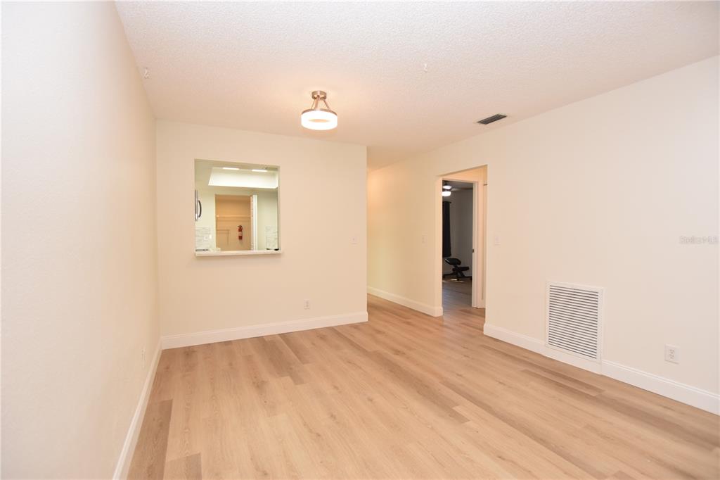 2025 Sylvester Road, Unit S2 Lakeland, FL 33803 - Photo 9 of 36 a view of an empty room with wooden floor and a window