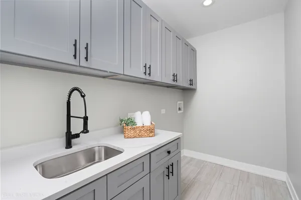 a close view of a sink and cabinets in wooden floor