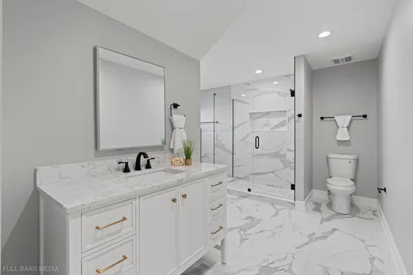 a bathroom with a sink a toilet and shower