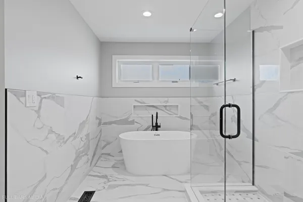 a bathroom with a granite countertop bathtub shower sink and white