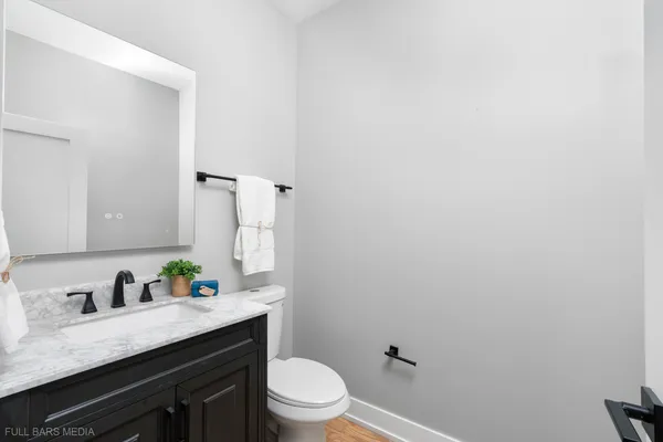 a bathroom with a granite countertop sink mirror vanity and toilet