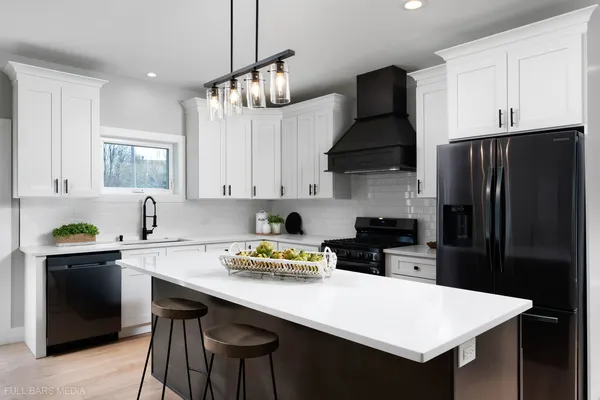a kitchen with stainless steel appliances a sink a stove a refrigerator and cabinets