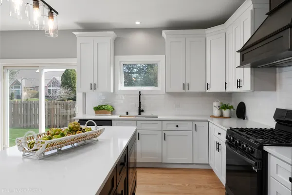 a kitchen with a sink a stove and cabinets
