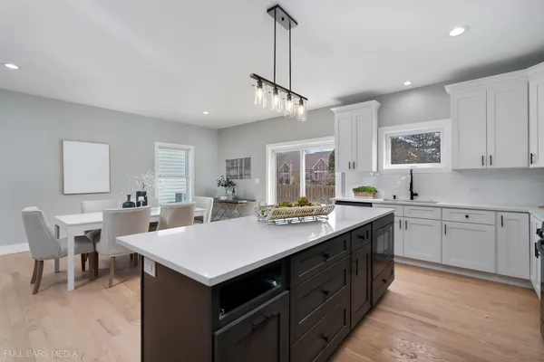 a kitchen with a stove a sink a dining table and chairs