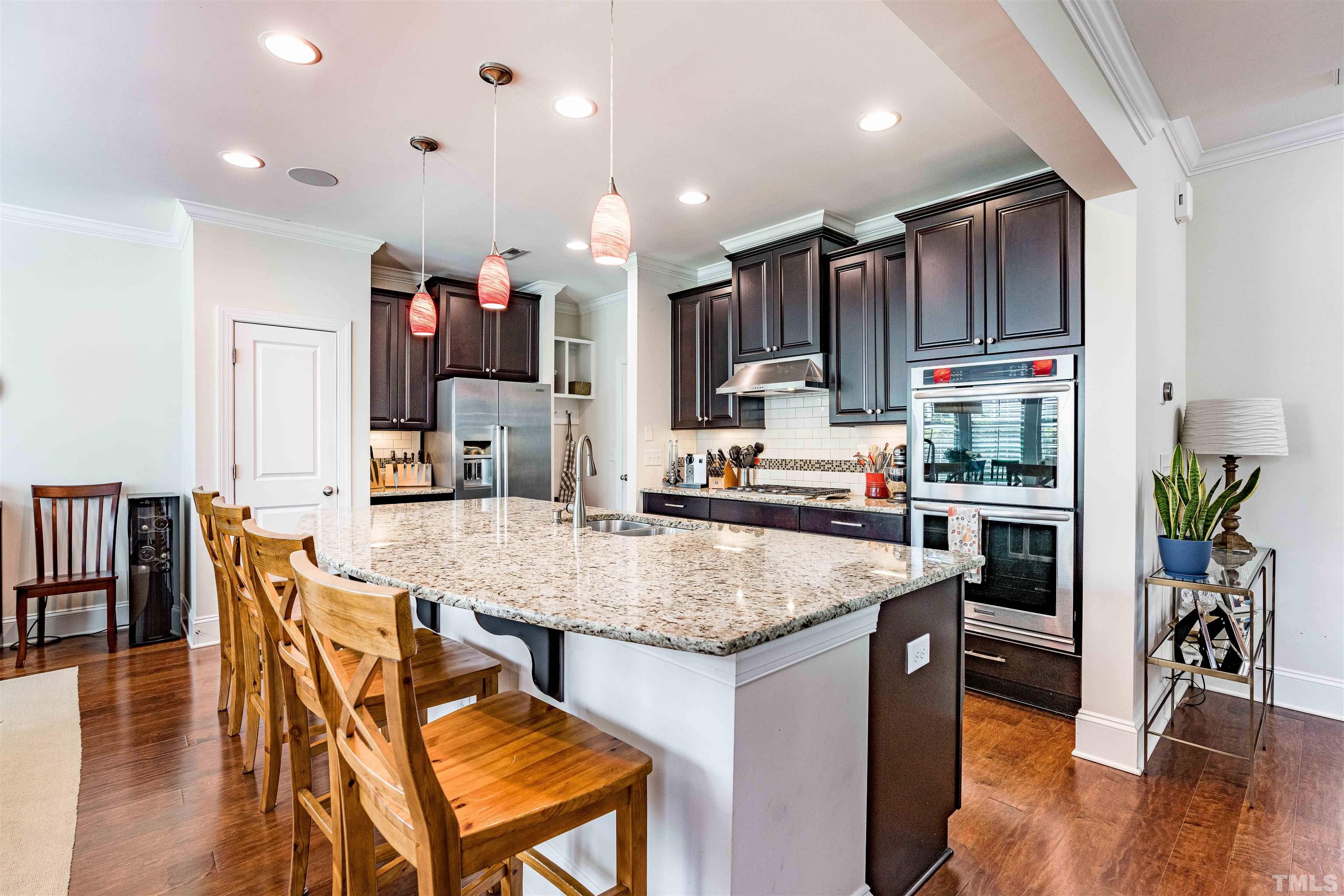 4020 Periwinkle Blue Lane Raleigh, NC 27612 - Photo 10 of 40 a kitchen with stainless steel appliances kitchen island granite countertop a table chairs refrigerator and microwave