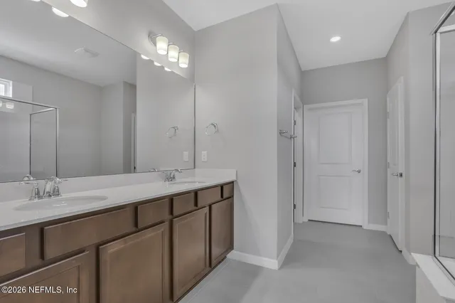 a bathroom with a double vanity sink and a mirror
