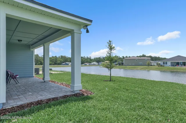 a view of a house with a yard and a lake view