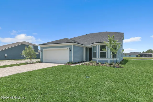 a front view of a house with a garden and yard