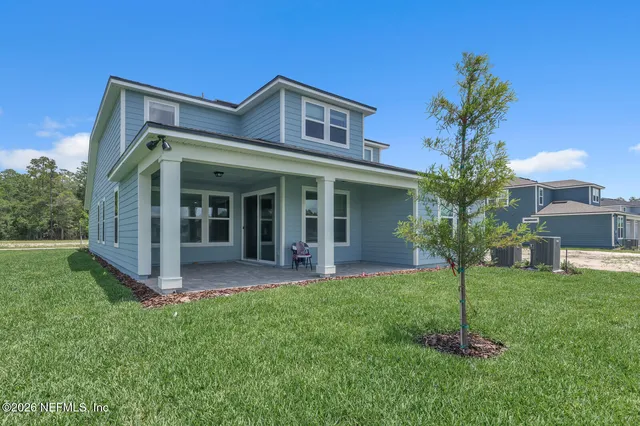 a view of a house with a yard and potted plants