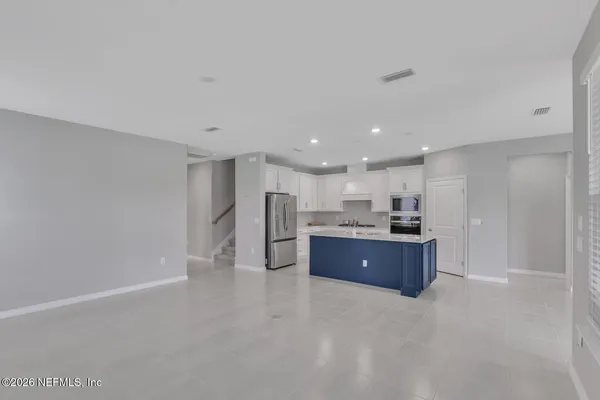 a large room with kitchen island stainless steel appliances lots of counter top space and cabinets