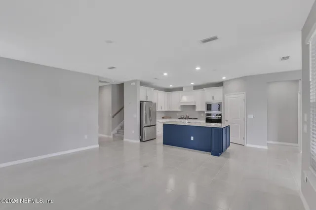 a large room with kitchen island stainless steel appliances lots of counter top space and cabinets