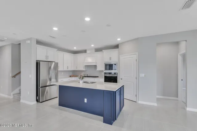 a kitchen with stainless steel appliances a sink a refrigerator and a stove top oven