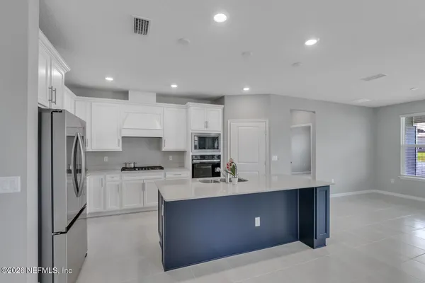 a kitchen with stainless steel appliances granite countertop a refrigerator and a stove top oven