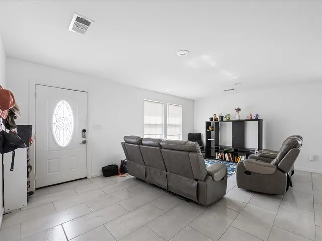 a living room with furniture a flat screen tv and a window