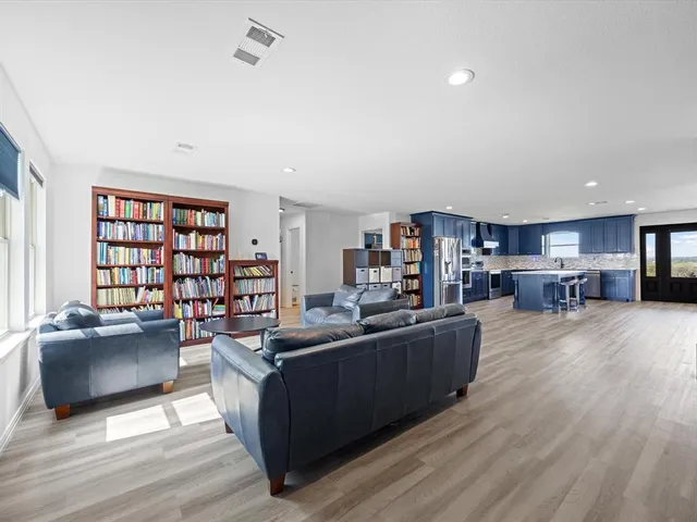 a kitchen with stainless steel appliances granite countertop wooden floors a stove and a refrigerator