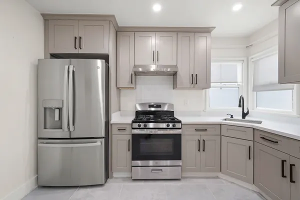 a kitchen with cabinets appliances a sink and a window