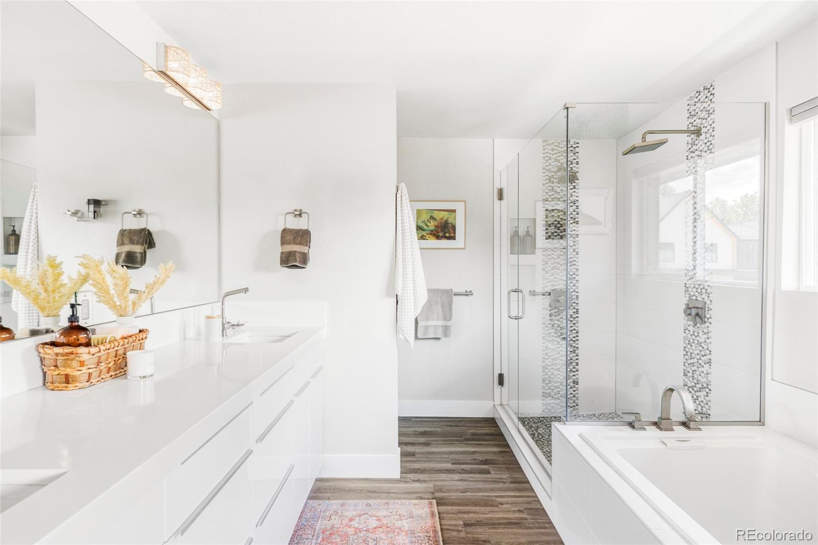3370 Ward Road Wheat Ridge, CO 80033 - Photo 25 of 42 a bathroom with a tub sink and mirror