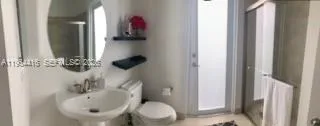 a bathroom with a sink and mirror with toilet