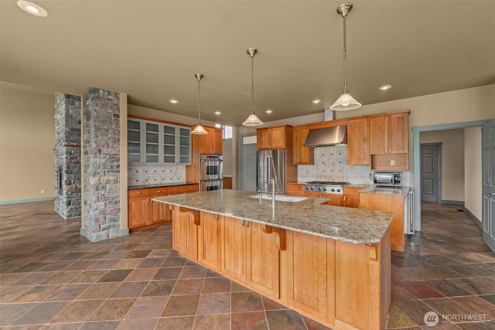 1900 Tamarack Street Colville, WA 99114 - Photo 9 of 40 a large kitchen with kitchen island granite countertop a large counter top and stainless steel appliances