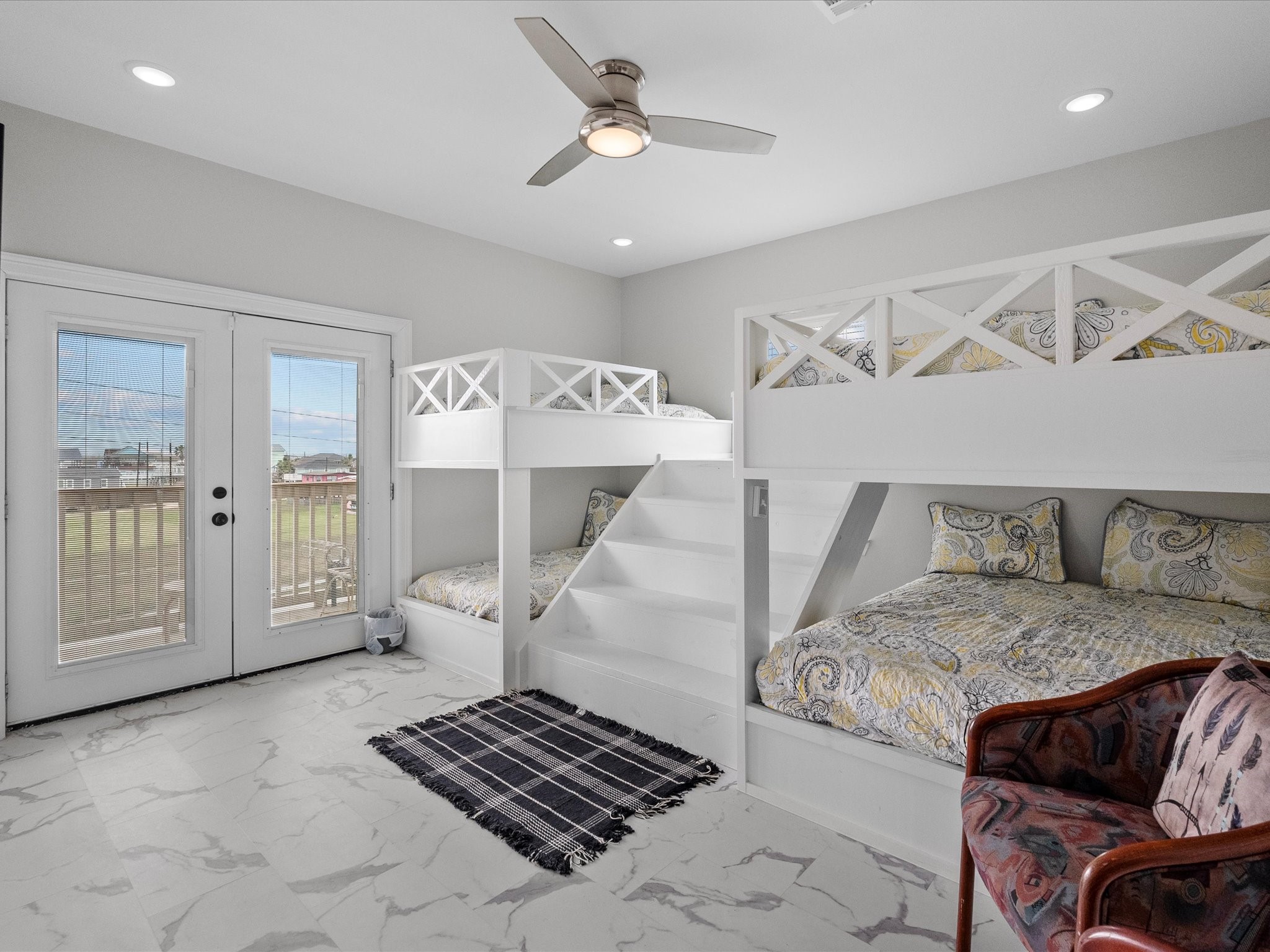 1018 Seashell Drive Surfside Beach, TX 77541 - Photo 36 of 49 This bright, spacious bedroom features built-in bunk beds with stylish bedding, a ceiling fan, and French doors leading to a small balcony with scenic views. Perfect for a kids' or guest room.