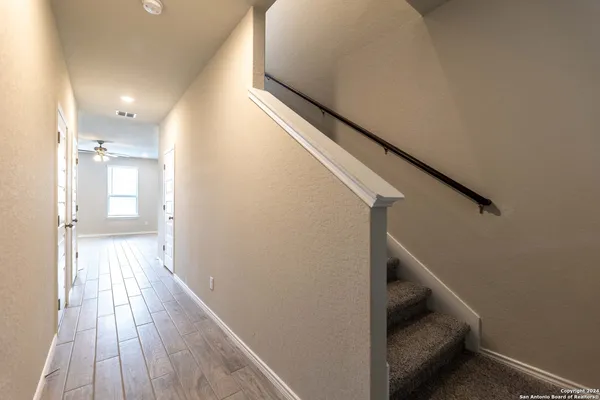 a view of a hallway with wooden floor and staircase