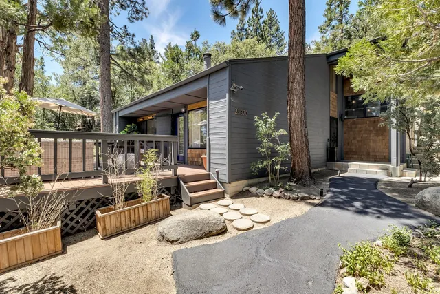 a balcony with wooden floor table and chairs