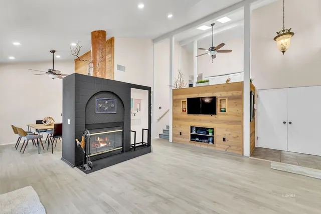 a kitchen with stainless steel appliances granite countertop a refrigerator a stove a sink a dining table and chairs