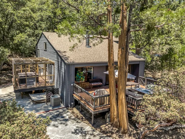 an aerial view of a house with a yard and large trees