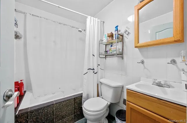 a bathroom with a sink a toilet and shower curtain