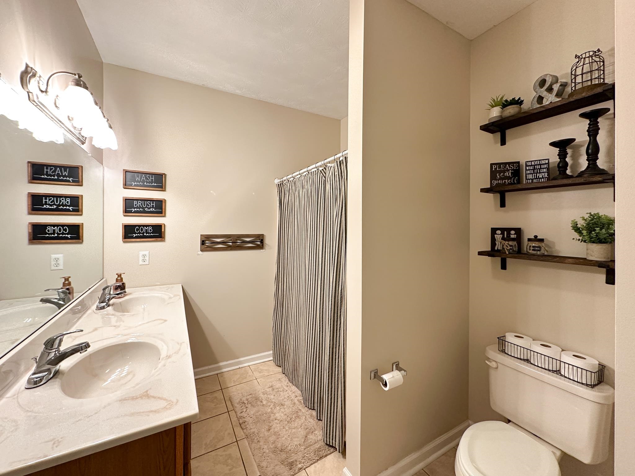 3427 Lyndhurst Road Stuarts Draft, VA 24477 - Photo 33 of 36 a bathroom with a sink a toilet and shower curtain